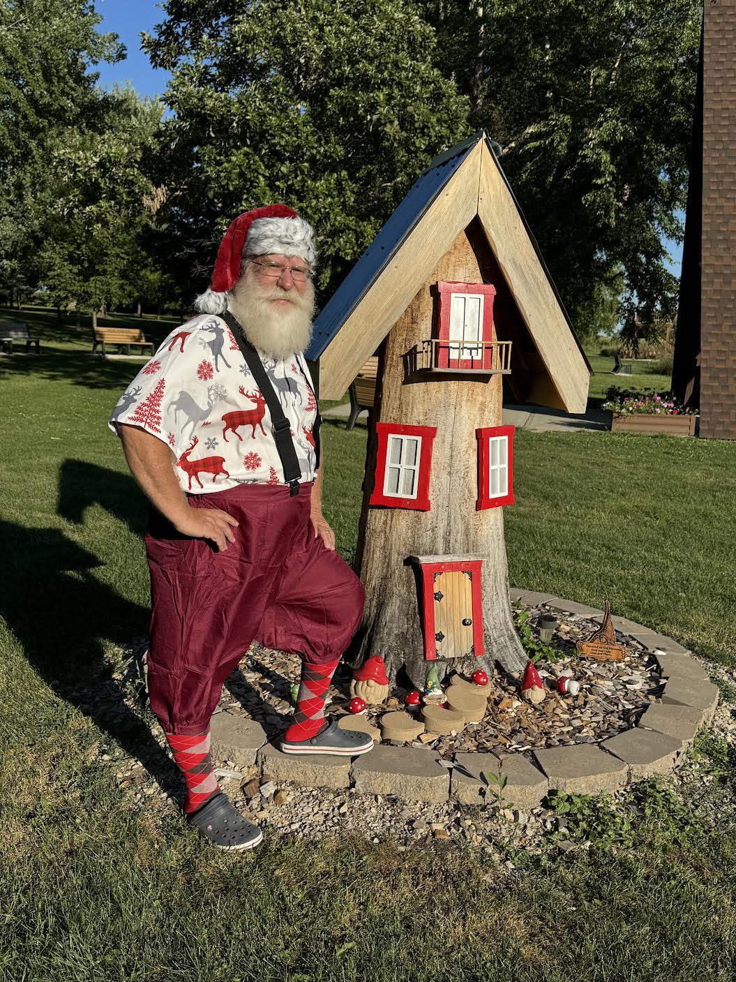 Santa Jangle by an elf treehouse in summer attire